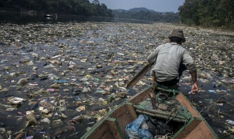 Warga menggunakan perahu untuk memilah sampah plastik di aliran sungai (ilustrasi)