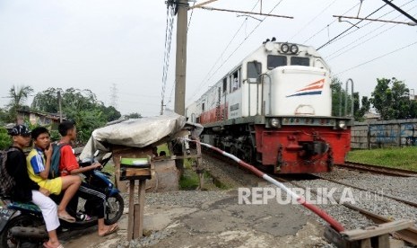  Warga menggunakan perlintasan kereta apa ilegal di Kawasan Buaran, Jakarta Timur, Kamis (23/3). 