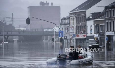 Warga menggunakan rakit karet di tengah banjir setelah Sungai Meuse jebol saat banjir besar di Liege, Belgia.