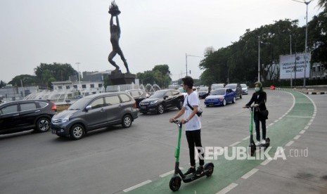 Warga menggunakan skuter listrik di kawasan Senayan, Jakarta, Sabtu (23/22/2019).