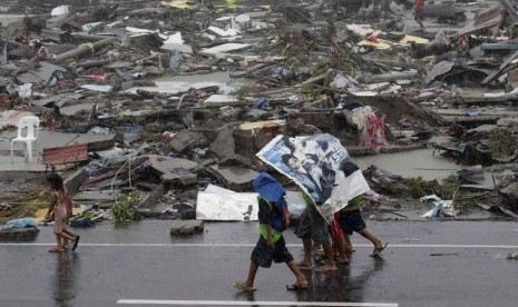  Warga menggunakan terpal untuk melindungi mereka dari hujan saat topan melanda kota Tacloban di provinsi Leyte, Filipina tengah, Ahad (10/11).  (AP/Bullit Marquez)