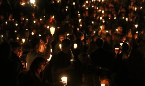 Warga menghadiri acara menyalakan lilin memperingati korban tewas di Umpqua Community College, Oregon, Kamis (1/10).