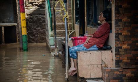 Warga menghindari genangan air yang merendam kawasan Kebon Pala, Jatinegara, Jakarta.