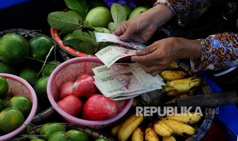 Warga menghitung uang saat melakukan penukaran uang Rupiah melalui Kas Terapung Kantor Perwakilan Bank Indonesia Provinsi Kalimantan Selatan di Pasar Terapung Desa Lok Baintan, Kabupaten Banjar, Kalimantan Selatan, Kamis (12/5).