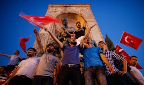 Warga mengibarkan bendera Turki saat berkumpul di Lapangan Taksim, Sabtu, 16 Juli 2016. Warga turun ke jalan menolak aksi kudeta terhadap Presiden Turki Recep Tayyip Erdogan.