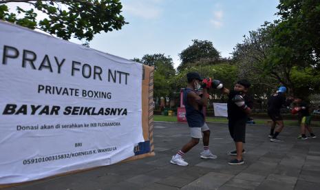 Warga mengikuti latihan tinju dengan berdonasi seikhlasnya dalam fighter Bali for NTT di Lapangan Puputan Margarana, Denpasar, Bali, Sabtu (10/4/2021). Donasi hasil dari kegiatan tersebut akan diserahkan ke Ikatan Keluarga Besar (IKB) Flobamora untuk membantu korban bencana badai siklon tropis seroja di Nusa Tenggara Timur.