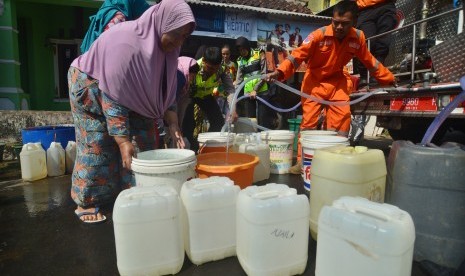 Warga mengikuti pembagian air bersih yang didistribusikan oleh Satlantas Polres Kota bekerja sama dengan BPBD Kota Tasikmalaya, Kampung Singkup, Jawa Barat, Selasa (19/9). 