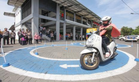 Warga mengikuti ujian praktek Surat Ijin Mengemudi (SIM) dalam program SIM Cak Bhabin di Pasar Gunung Anyar, Surabaya, Jawa Timur, Selasa (27/9/2022). Program SIM Cak Bhabin dari Satlantas Polrestabes Surabaya itu bertujuan untuk mempermudah masyarakat dalam mendapatkan layanan permohonan SIM dengan menjalani serangkaian ujian SIM di lokasi yang ditentukan di luar Satpas Colombo Surabaya. 