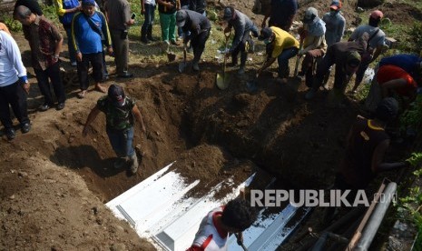 Warga mengubur jenazah terduga teroris di pemakaman Pucang, Sidoarjo, Jawa Timur, Ahad (20/5). 