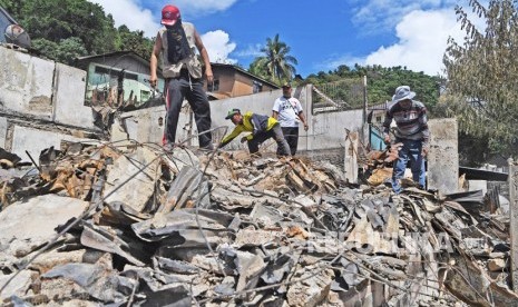 Warga mengumpulkan benda yang masih berharga dari sisa kebakaran rumah warga di Kota Jayapura, Papua, Senin (2/9/2019).