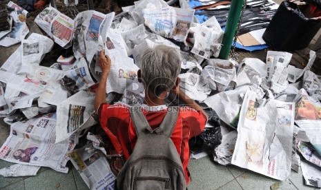 Warga mengumpulkan koran bekas di halaman masjid Cut Mutia, Jakarta, Jumat (27/2).