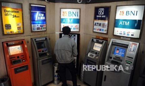  Warga mengunakan fasilitas Anjungan Tunai Mandiri (ATM) di Jakarta, Senin (18/1).