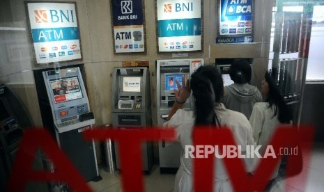 Warga mengunakan fasilitas Anjungan Tunai Mandiri (ATM) di Jakarta, Senin (18/1). 