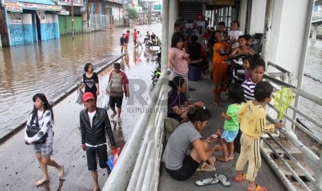  Warga mengungsi di Halte Bus Transjakarta Taman Kota di Jalan Daan Mogot, Jakarta Barat, Ahad (19/1). ( Republika/Yasin Habibi)