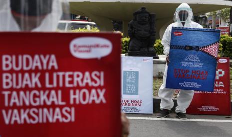 Warga mengusung poster bertajuk Peduli Literasi Anti Hoax Vaksinasi saat aksi di Jalan Gajah Mada, Solo, Jawa Tengah, Selasa (9/2/2021). Aksi tersebut digelar untuk memperingati Hari Pers Nasional sekaligus mengajak masyarakat agar bijak bersosial media dan tidak mudah menyebar berita hoax.