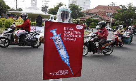 Warga mengusung poster bertajuk Peduli Literasi Anti Hoax Vaksinasi saat aksi di Jalan Gajah Mada, Solo, Jawa Tengah, Selasa (9/2/2021). Aksi tersebut digelar untuk memperingati Hari Pers Nasional sekaligus mengajak masyarakat agar bijak bersosial media dan tidak mudah menyebar berita hoax. 