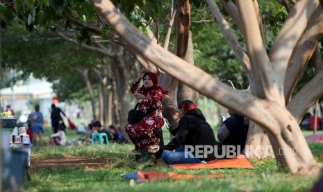  Warga menikmati suasana sore di tepi Waduk Pluit, jakarta utara, Kamis (29/6).