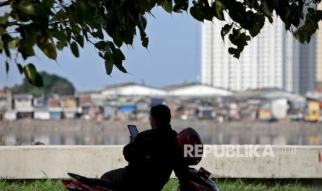  Warga menikmati suasana sore di tepi Waduk Pluit, jakarta utara, Kamis (29/6).