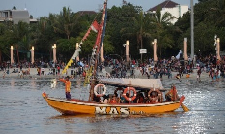   Warga menikmati wisata di pantai Ancol, Jakarta Utara.  (Republika/Yasin Habibi)