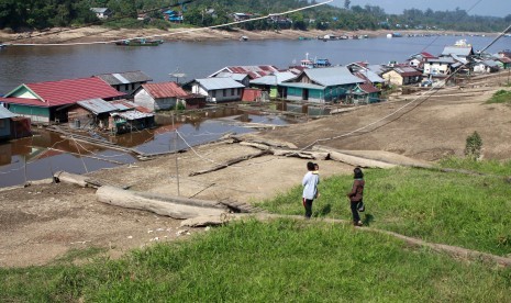 Warga meniti kayu bulat yang berfungsi sebagai jalan menuju tempat tinggalnya di rumah terapung Sungai Barito di Muara Teweh, Barito Utara, Kalimantan Tengah, Selasa (7/7). 