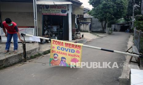 Warga menjaga pintu masuk ke pemukiman yang ditutup karena menjadi daerah zona merah penyebaran COVID-19 di Pamulang Barat, Tangerang Selatan, Banten, Rabu (23/6/2021). Lockdown lokal dilakukan karena sebanyak 17 warga di daerah itu terpapar COVID-19. 