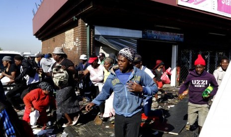 Warga menjarah sebuah toko di Germiston, di timur Johannesburg, Afrika Selatan, Selasa (3/9).