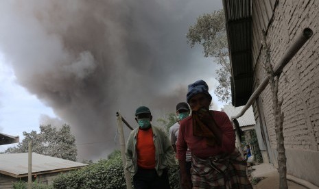 Warga menjauh dari Gunung Sinabung ketika erupsi, di Desa Sukandebi, Karo, Sumatera Utara, Selasa (24/5). (Antara/Irsan Mulyadi)