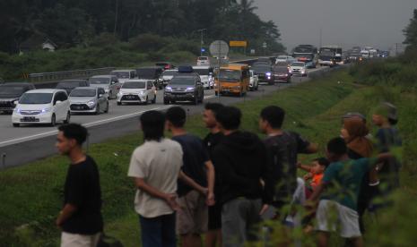 Warga menonton antrean kendaraan pemudik yang melintas di Jalan Tol Solo-Semarang, Suruh, Kabupaten Semarang, Jawa Tengah. Pengamat sebut pemudik menggunakan kendaraan pribadi dan akan macet di jalan tol.