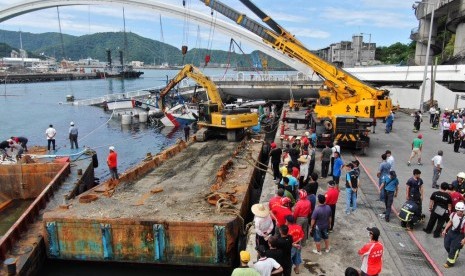 Warga menonton operasi penyelamatan korban ambruknya jembatan di Nanfangao, Taiwan, Selasa (1/10). 