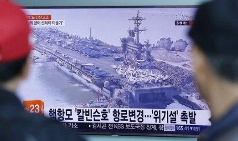 Warga menonton program berita yang menampilkan foto kapal induk AS, USS Carl Vinson di stasiun kereta Seoul, Korea Selatan, 12 April 2017. USS Carl Vinson dalam perjalanan menuju Semenanjung Korea.