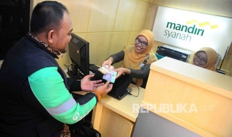 Warga menukarkan uang pecahan kecil di mobil kas kelilinga Bank Syariah Mandiri (BSM) di IRTI Monas, Jakarta, Senin (20/6).