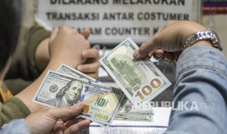 Warga menukarkan mata uang dolar AS di sebuah gerai money changer, Jakarta, Jumat (28/2/2020).(Antara/Galih Pradipta)