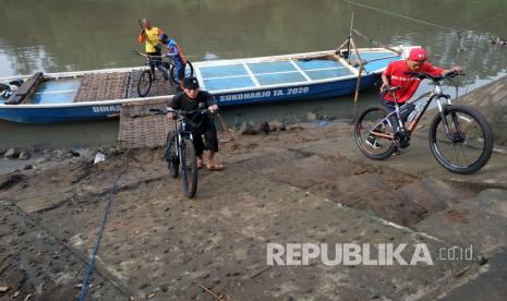 Warga menumpang perahu bantuan Dinas Perhubungan (Dishub) Kabupaten Sukoharjo yang melintas di sungai Bengawan Solo, Jawa Tengah, Selasa (26/5/2020). Perahu penyeberangan berbahan viber tersebut menggantikan perahu tambang dari bambu yang beroperasi 24 jam untuk menghubungkan Desa Kampung Sewu di wilayah Solo dengan Desa Gadingan di wilayah Sukoharjo, guna membantu memperlancar perekonomian masyarakat sekitar. 