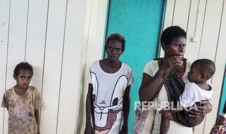 Warga menunggu antrean saat berobat di puskesmas Ayam di kampung Bayiwpinam, Distrik Akat, Kabupaten Asmat, Papua, Jumat (26/1). 