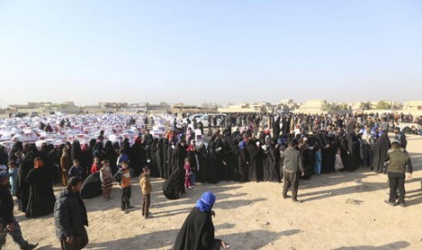 Warga menunggu pembagian bantuan kemanusiaan di luar Mosul, Irak, Senin, 28 November 2016. 