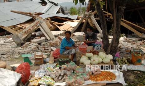 Warga menunggu pembeli di antara reruntuhan bangunan akibat gempa di Petobo, Palu, Sulawesi Tengah, Kamis (4/10).