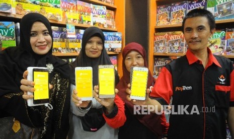 Warga menunjukan aplikasi PayTren di toko buku Gramedia, Jakarta, Rabu (5/4). 