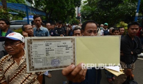 Warga menunjukan BPKB saat antre untuk mengurus perpanjangan di Direkorat Lalu Lintas Polda Metro Jaya, Jakarta, Kamis (5/1).