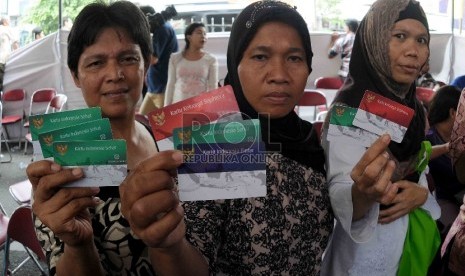 Warga menunjukan Kartu Indonesia Sehat (KIS), Kartu Keluarga Sejahtera (KKS) dan Kartu Indonesia Pintar (KIP) saat pembagian tiga jenis kartu sakti itu di Kampung Melayu, Jakarta Timur, Rabu (13/5). (Republika/Agung Supriyanto)