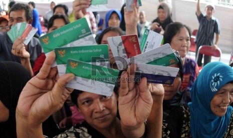 Warga menunjukan Kartu Indonesia Sehat (KIS), Kartu Keluarga Sejahtera (KKS) dan Kartu Indonesia Pintar (KIP) saat pembagian tiga jenis kartu sakti itu di Kampung Melayu, Jakarta Timur, Rabu (13/5). (Republika/Agung Supriyanto)