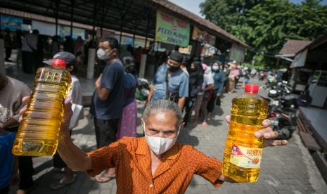 Warga menunjukan minyak goreng kemasan dengan Harga Eceran Tertinggi (HET) Rp14 ribu per liter saat Operasi Pasar Bulog di Mojosongo, Solo, Jawa Tengah, Rabu (23/2/2022). Operasi pasar tersebut dilakukan untuk menstabilkan harga minyak goreng dipasaran sekaligus upaya mengatasi kelangkaan.