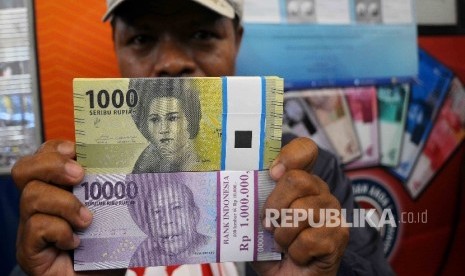  Warga menunjukan uang rupiah baru (ilustrasi) 