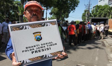 Warga menunjukkan bantuan paket sembako yang didapatnya di kawasan Joyoboyo, Surabaya, Jawa Timur, Rabu (14/9/2022). Pembagian bantuan dari Polda Jawa Timur kepada sejumlah pengayuh becak di kawasan itu untuk membantu meringankan beban ekonomi mereka pascakenaikan harga bahan bakar minyak (BBM). 