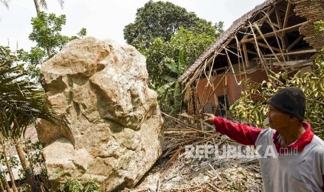 Warga menunjukkan bongkahan batu sebesar sekitar 6x5 meter yang menimpa sejumlah bangunan di Kampung Cihandeuleum, Desa Sukamulya, Tegalwaru, Purwakarta, Jawa Barat, Rabu (9/10). Sejak awal tahun 2020 tercatat sudah ada 12 kali bencana longsor yang terjadi di Purwakarta.