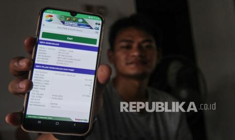   Warga menunjukkan informasi pembayaran pajak kendaraan melalui E-Samsat aplikasi Samsat Mobile Jawa Barat (Sambara) di Tapos, Depok, Jawa Barat, Kamis (14/10/2021). (ilustrasi)