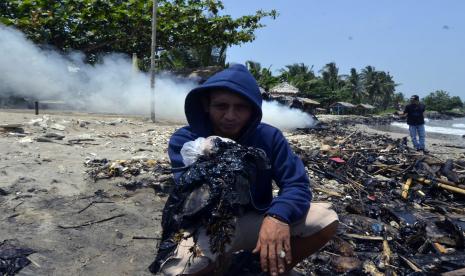 Warga menunjukkan tumpahan limbah minyak ilustrasi. Dinas Lingkungan Hidup (DLH) Provinsi Lampung menyatakan hasil uji laboratorium terhadap limbah minyak PT Pertamina Hulu Energi (PHE) Offshore Southeast Sumatra (OSES) yang beberapa waktu lalu ditemukan di Pantai Lampung Timur masuk dalam kategori di bawah ambang batas.