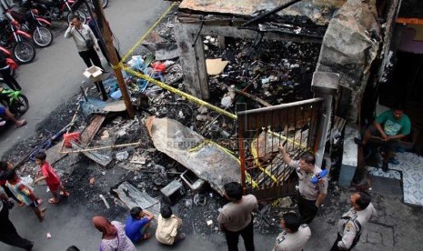   Warga menyaksikan bangunan yang terbakar akibat tawuran antarwarga di Johar Baru, Jakarta Pusat, Senin (18/11). (Republika/Yasin Habibi)