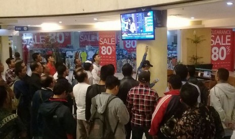 Warga menyaksikan debat Cagub DKI melalui layar TV di sebuh mal di Jakarta. 