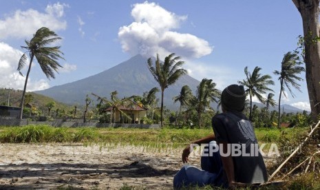 Warga menyaksikan Gunung Agung memuntahkan abu dan asap di Karangasem, Bali, Rabu (4/7).