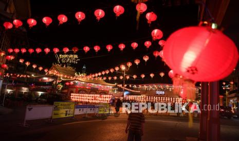 Warga menyaksikan hiasan lampion yang dipasang di Singkawang, Kalimantan Barat, Kamis (27/1/2022). Perayaan Imlek 2022 dan Cap Go Meh di Singkawang, Kalimantan Barat akan dilaksanakan secara terbatas sesuai aturan PPKM yang berlaku.